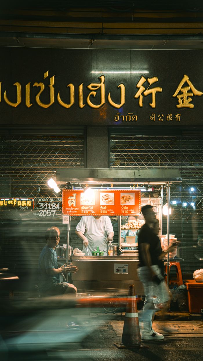 Vibrant nighttime street food scene in a bustling urban Chinatown.