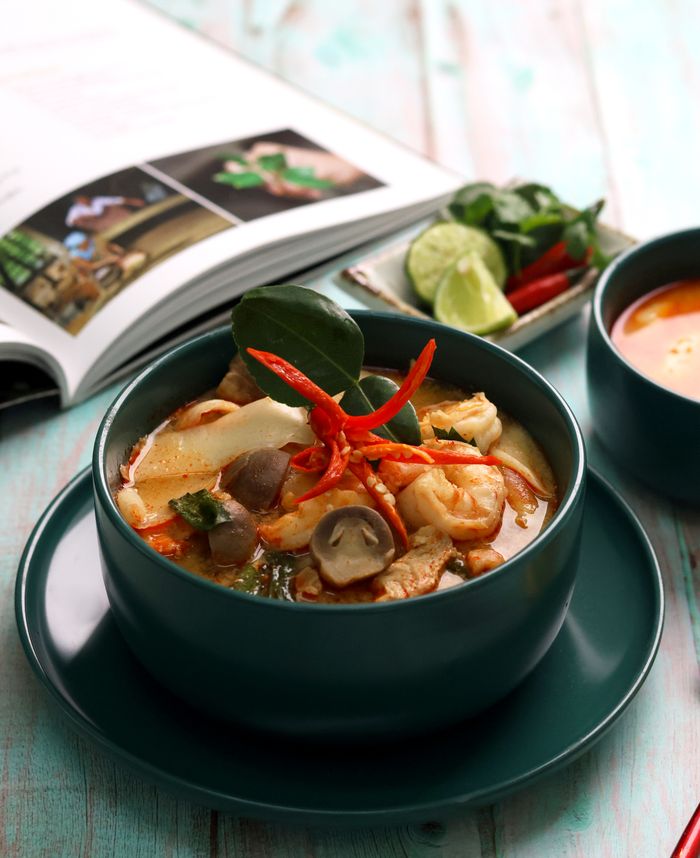 Close-up of delicious Tom Yum soup, a traditional Thai dish, beautifully presented.